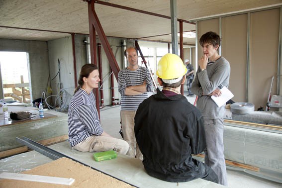 Vier Personen beraten sich beim Innenausbau eines Hauses.
