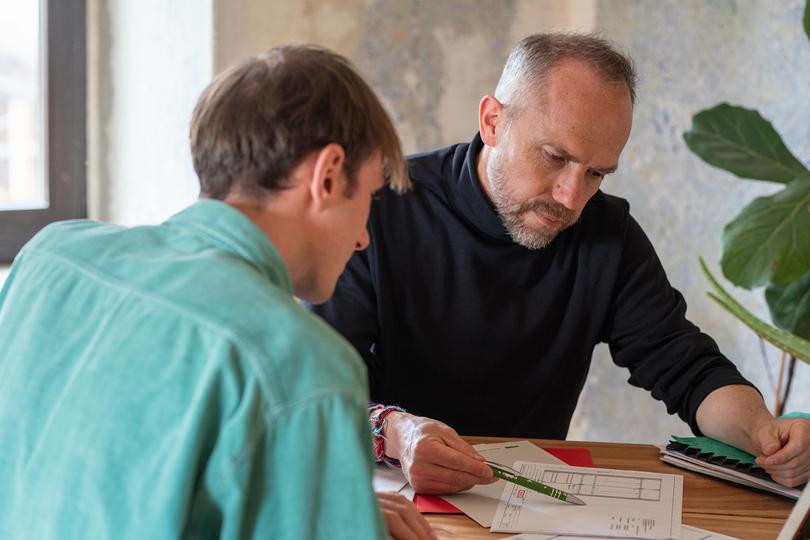 Zwei Männer besprechen eine Finanztabelle